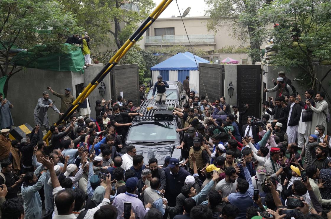 A vehicle carrying former Prime Minister Imran Khan is surrounded by his supporters as he leaves for Islamabad from his residence in Lahore, Pakistan, March 18, 2023. (AP Photo)