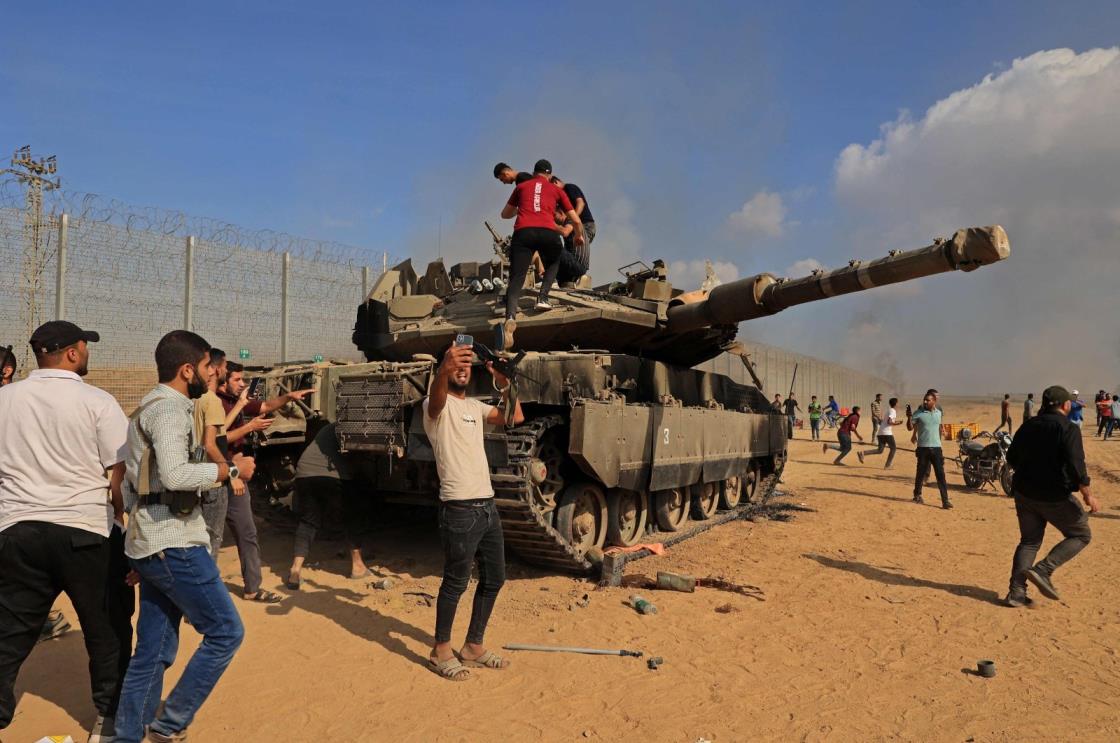 Palestinians take co<em></em>ntrol of an Israeli tank after crossing the border fence with Israel from Khan Yunis in the southern Gaza Strip, Palestine, Oct. 7, 2023. (AFP Photo)