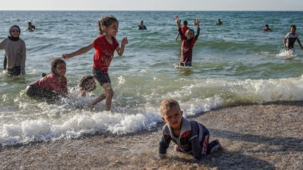 加沙战争:巴勒斯坦人在海滩上寻求战争和炎热的喘息，以色列人对此感到愤怒
